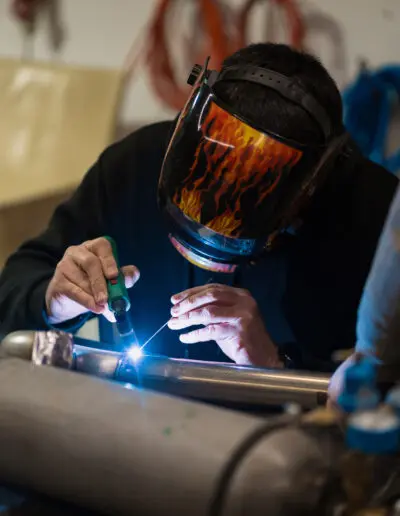 Man working with argon welding machine in a garage
